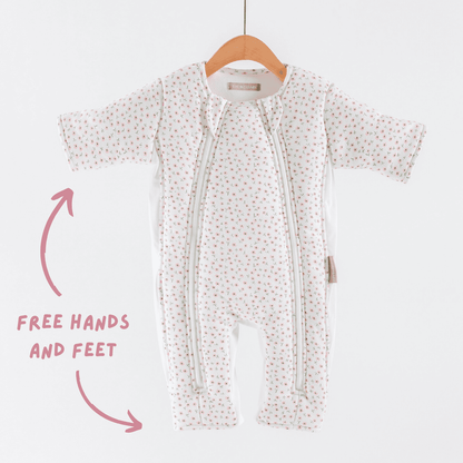 Baby transition suit with free hands and feet feature on a hanger against a white background