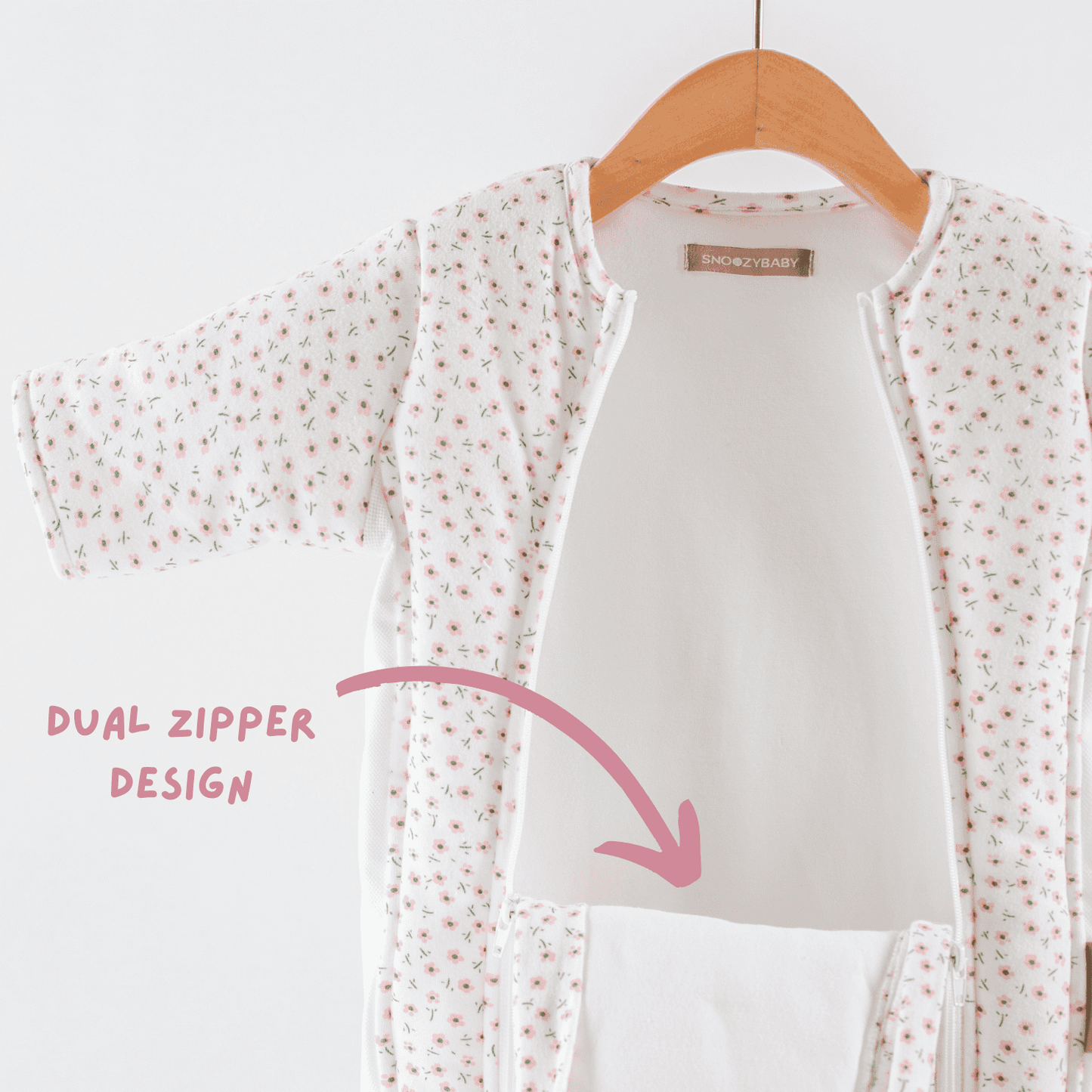Baby girls sleepsuit with floral pattern and double zipper design on a hanger against a white background.