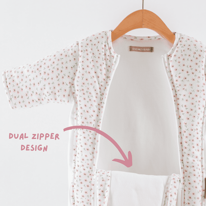 Baby girls sleepsuit with floral pattern and double zipper design on a hanger against a white background.