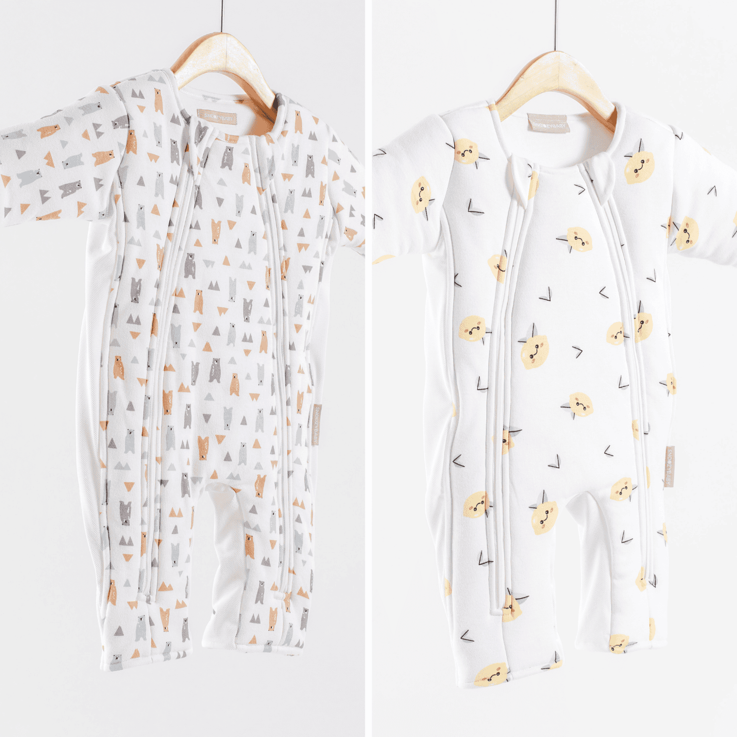 Two baby sleepsuits with different patterns on hangers against a white background