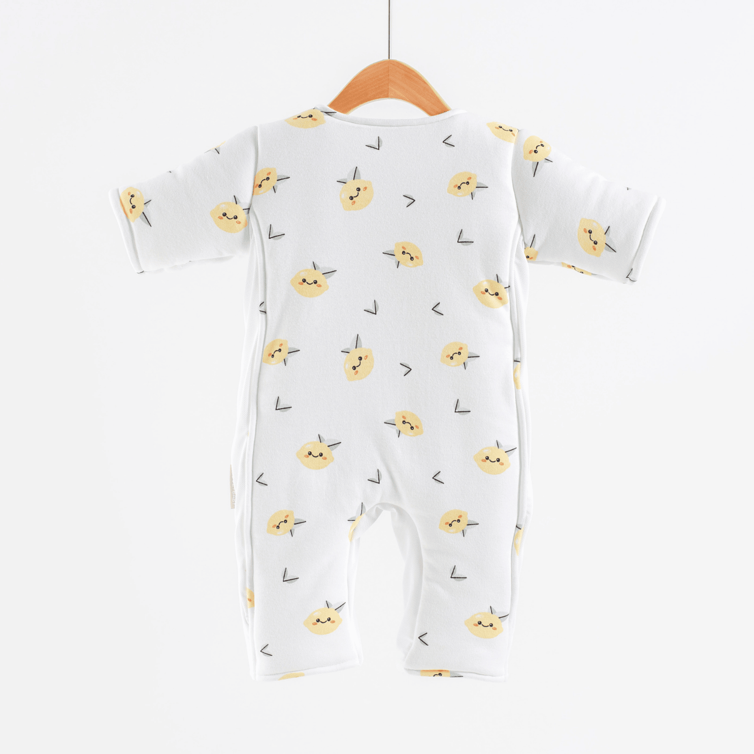 Baby onesie with yellow lemon pattern on a hanger against a white background