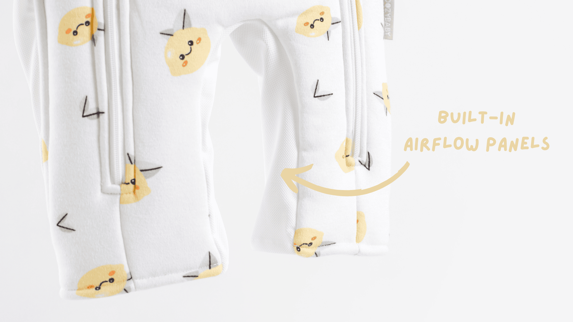 White infant sleepsuit with yellow lemon face print on a white background showing breathable mesh panels