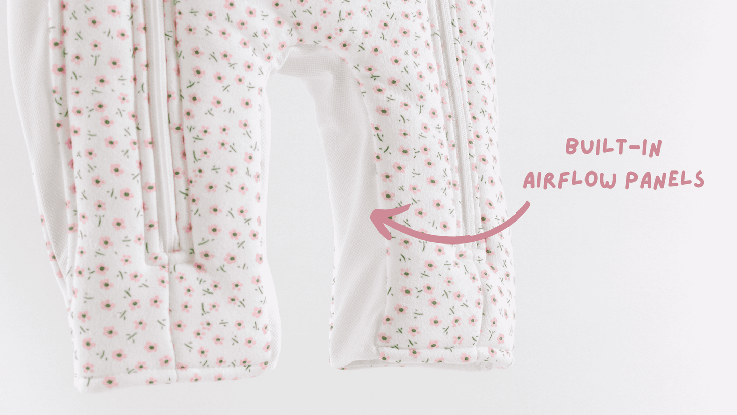Breathable floral-patterned baby sleepsuit with built-in airflow panels on a white background