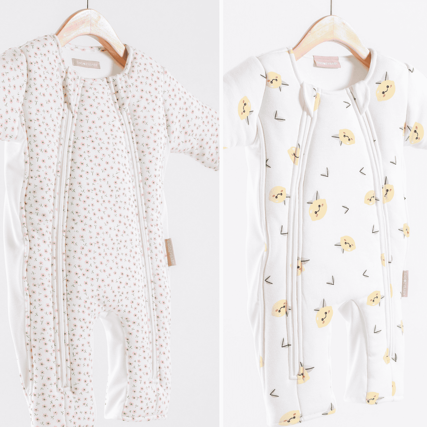 Two infant sleepsuits on hangers with different patterns against a white background
